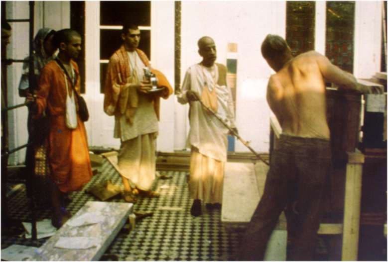 Srila Prabhupada with disciples in a temple room under renovation